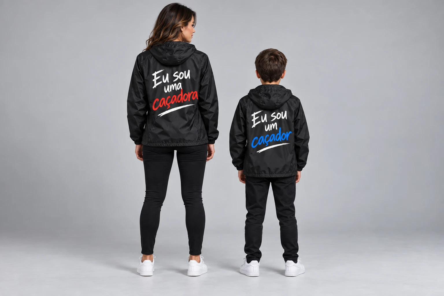 Modelo adulta e modelo infantil usando corta-ventos pretos: Eu sou uma caçadora em vermelho e Eu sou um caçador em azul.